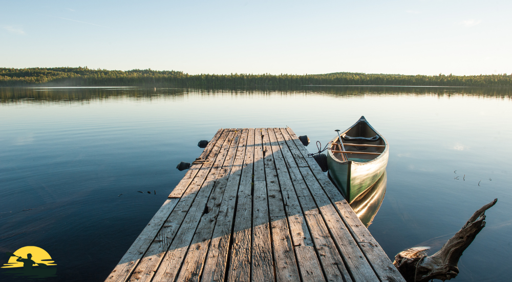 A canoe is parked besides a lake