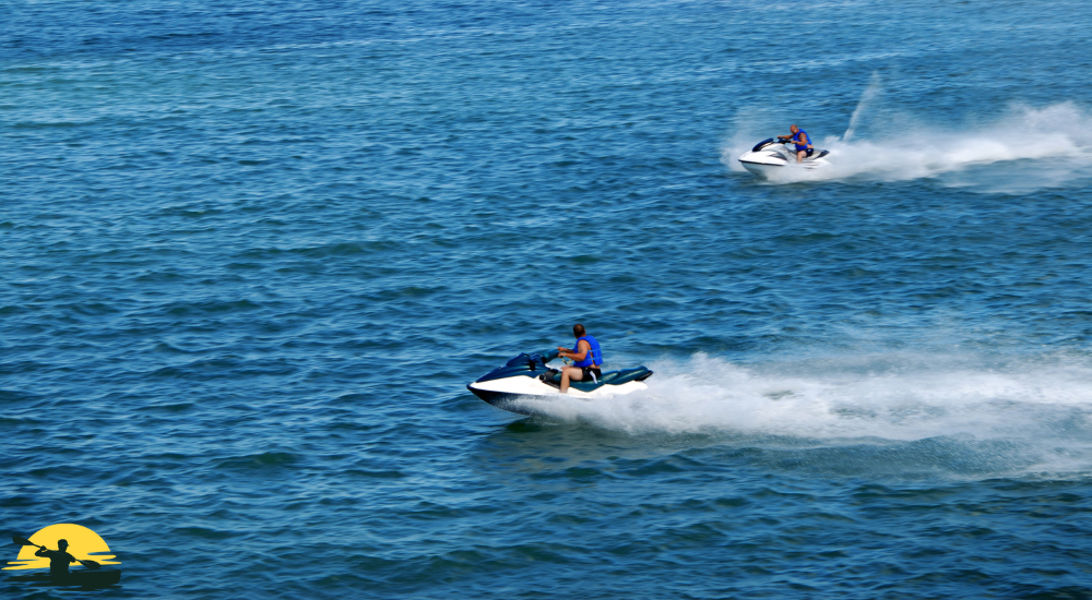 Two man are riding jet skis on the water