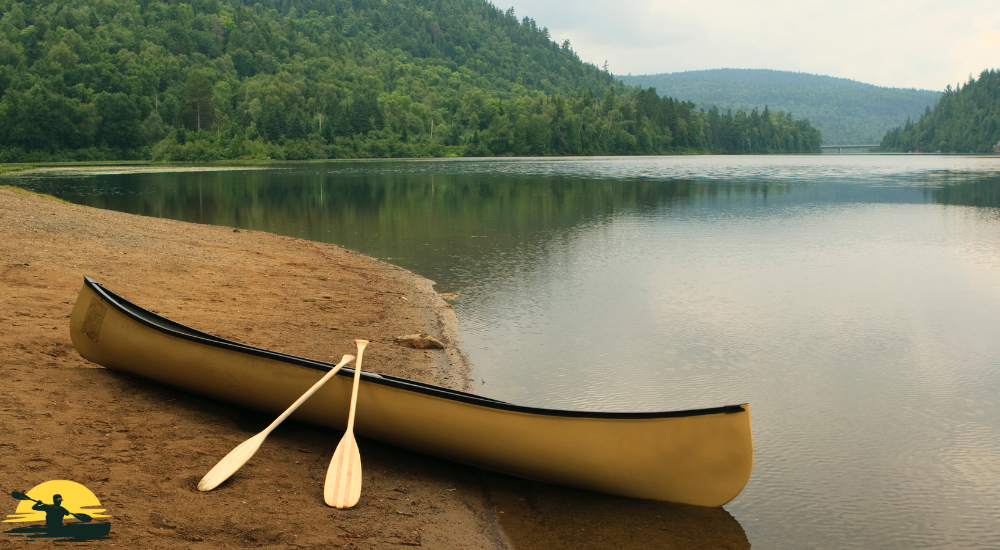 A canoe besides a lake 
